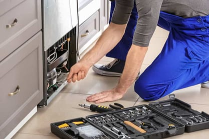 Appliance repairman working on dishwasher repair. Appliance repairman working on dishwasher repair.