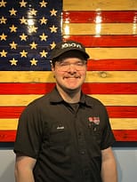 Appliance repairman standing in front of an American Flag.